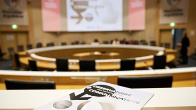 magazine en 1er plan dans salle plénière